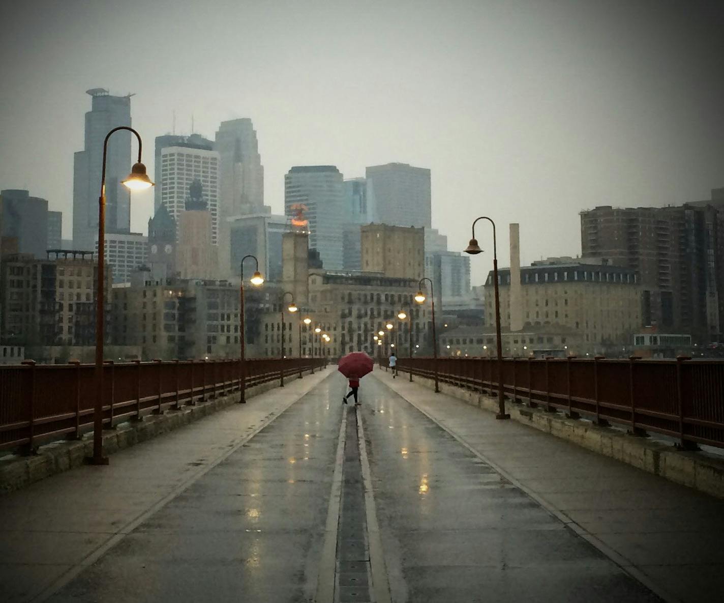 A young woman walked along the Stone Arch Bridge as a storm approached Minneapolis. ] MCKENNA EWEN mckenna.ewen@startribune.com - May 8, 2014, Minneapolis Star Tribune