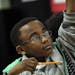 Fifth grader Jeremiah Jones raises his hand to answer a question during math class on an in-class assignment using iPads and an app called Socrative t