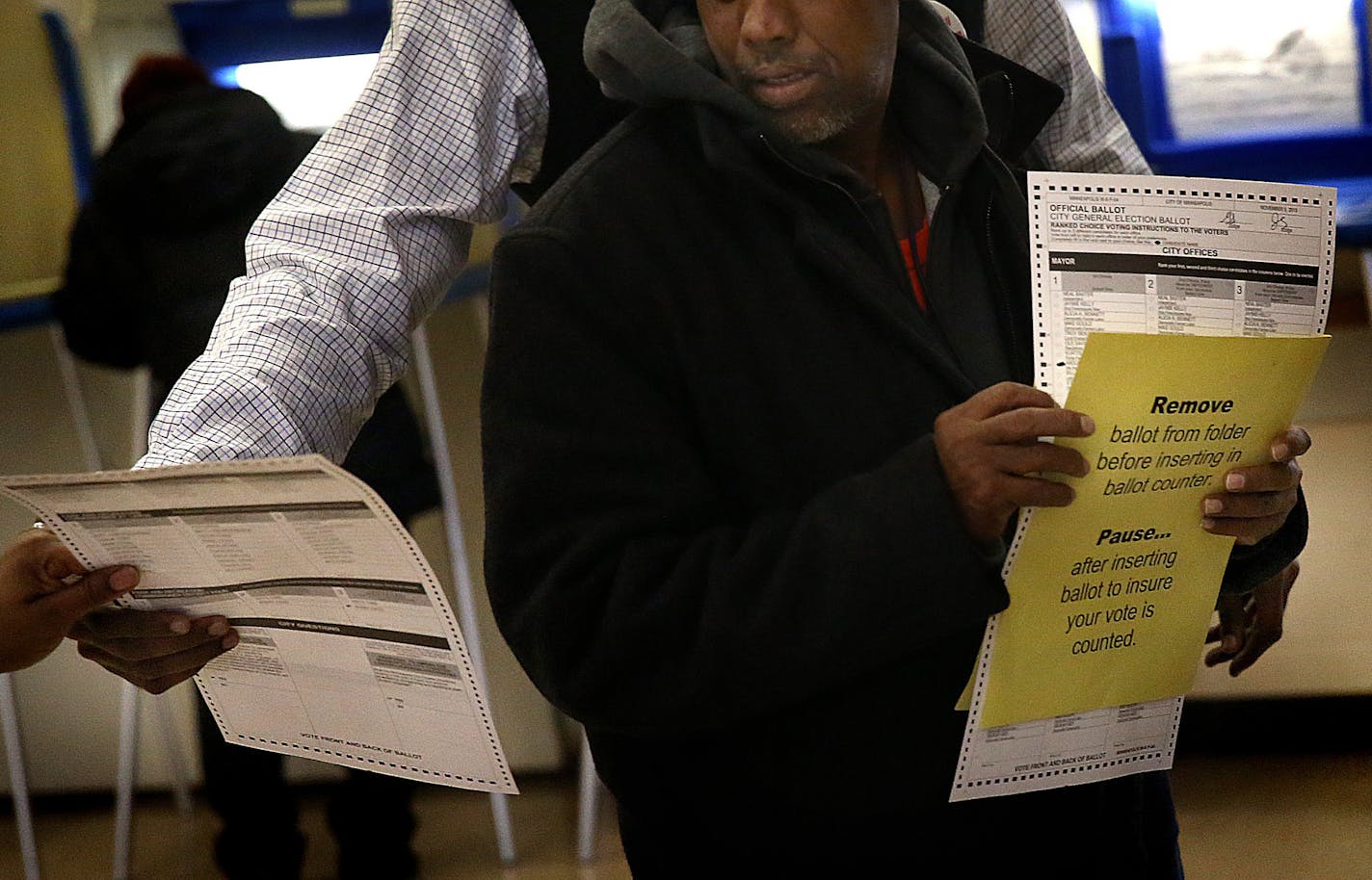 A voter received help from election officials at the Elliot Park Recreation Center after having cast a ballot that was rejected by the voting machine for apparently having some marks that could not be read accurately by the machine. ] (JIM GEHRZ/STAR TRIBUNE) / November 5, 2013, Minneapolis, MN &#x201a;&#xc4;&#xec; BACKGROUND INFORMATION- Voters cast their ballots at the Elliot Park Recreation Center in Minneapolis. The city&#x201a;&#xc4;&#xf4;s ballot includes more than 30 candidates for mayor,