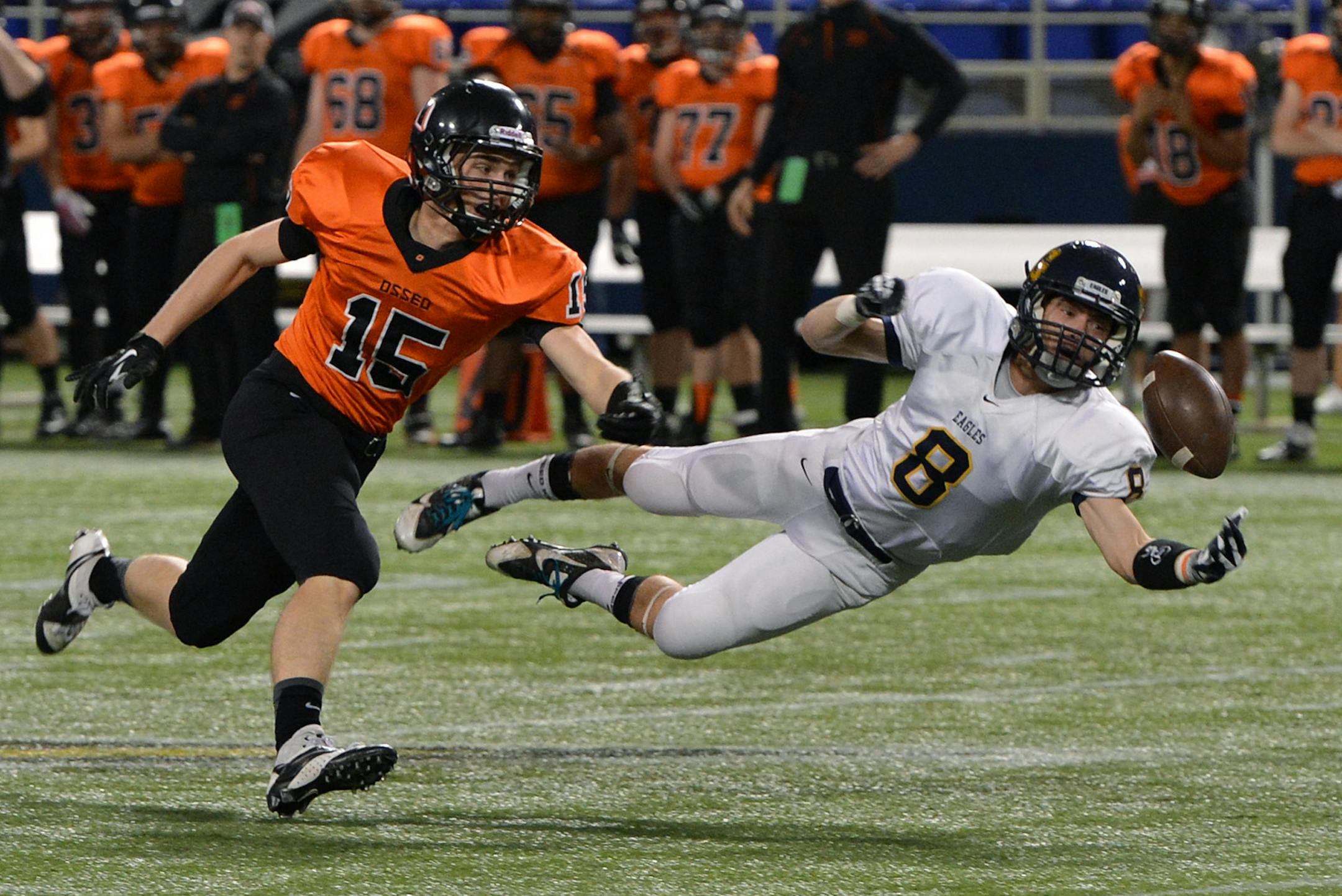 Totino-Grace's Ben Mezzenga reaches, but fails to intercept a pass meant for Osseo's Joshua Goldschmidt during the first half of a Class 6A state football quarterfinal game Friday night at the Metrodome. Osseo led 20-12 at the half. ] (SPECIAL TO THE STAR TRIBUNE/BRE McGEE) **Ben Mezzenga (white, 8), Joshua Goldschmidt (orange, 15) ORG XMIT: MIN1311082203019699