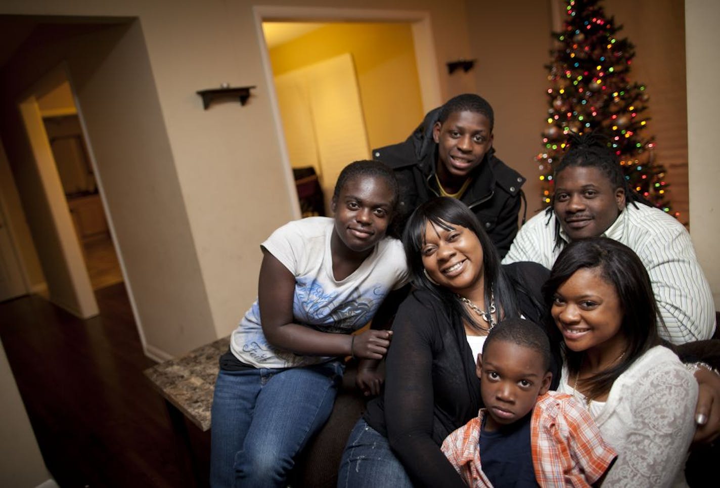 Tawana Reliford, center in black, is a first time home buyer and she used homebuyer assistance programs to buy her St. Paul home. She posed for a picture with her family in St. Paul, Minn., Thursday, December 15, 2011. Clockwise from the left is her children Jasmine Reliford, 16, Albert Reliford, 15, fianc� Rashon Hassell, and children Shanique Reliford, 20, and Rashon Hassell, 5.