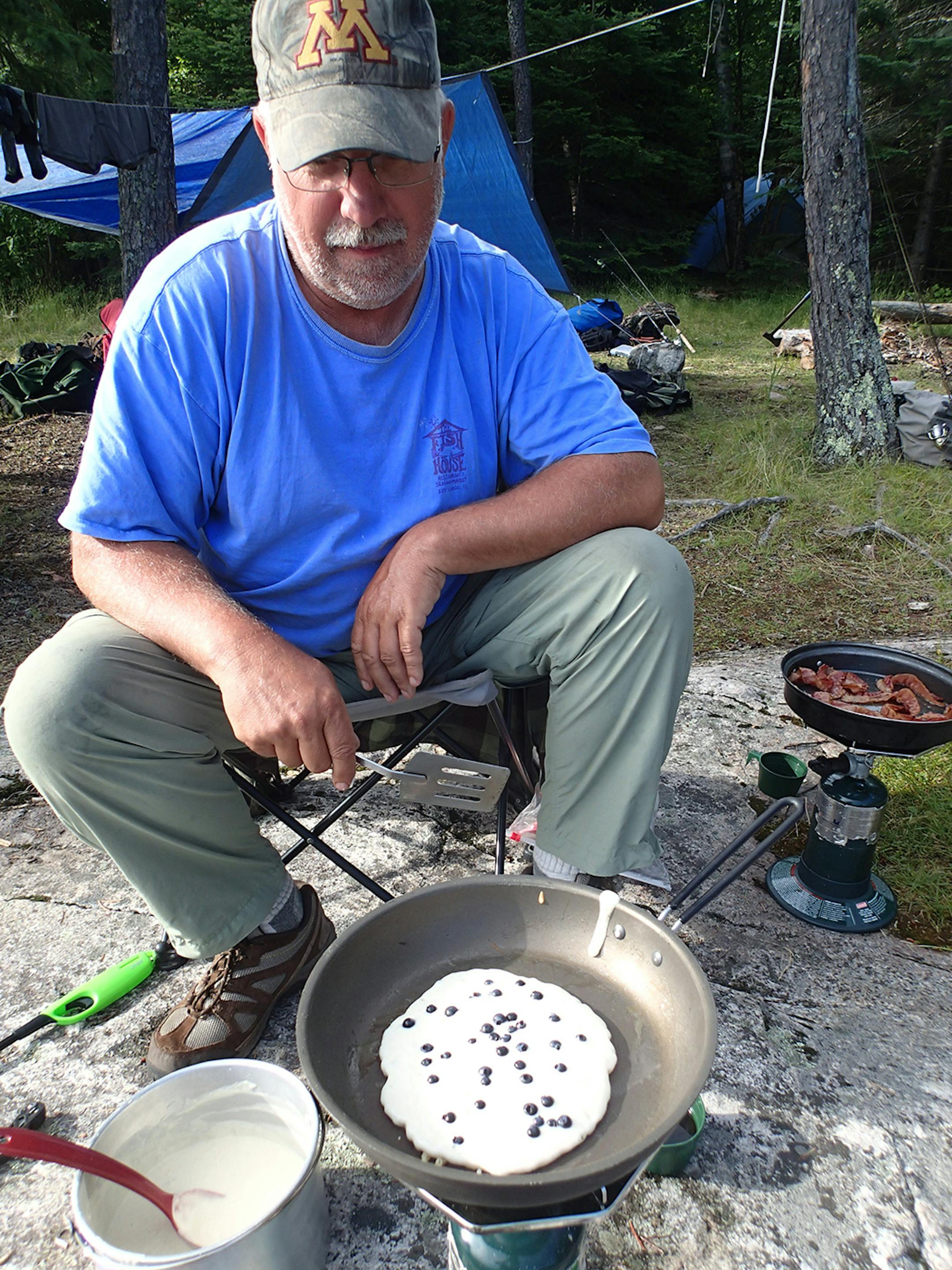 Dave Swenson cooks blueberry pancakes at camp one morning.