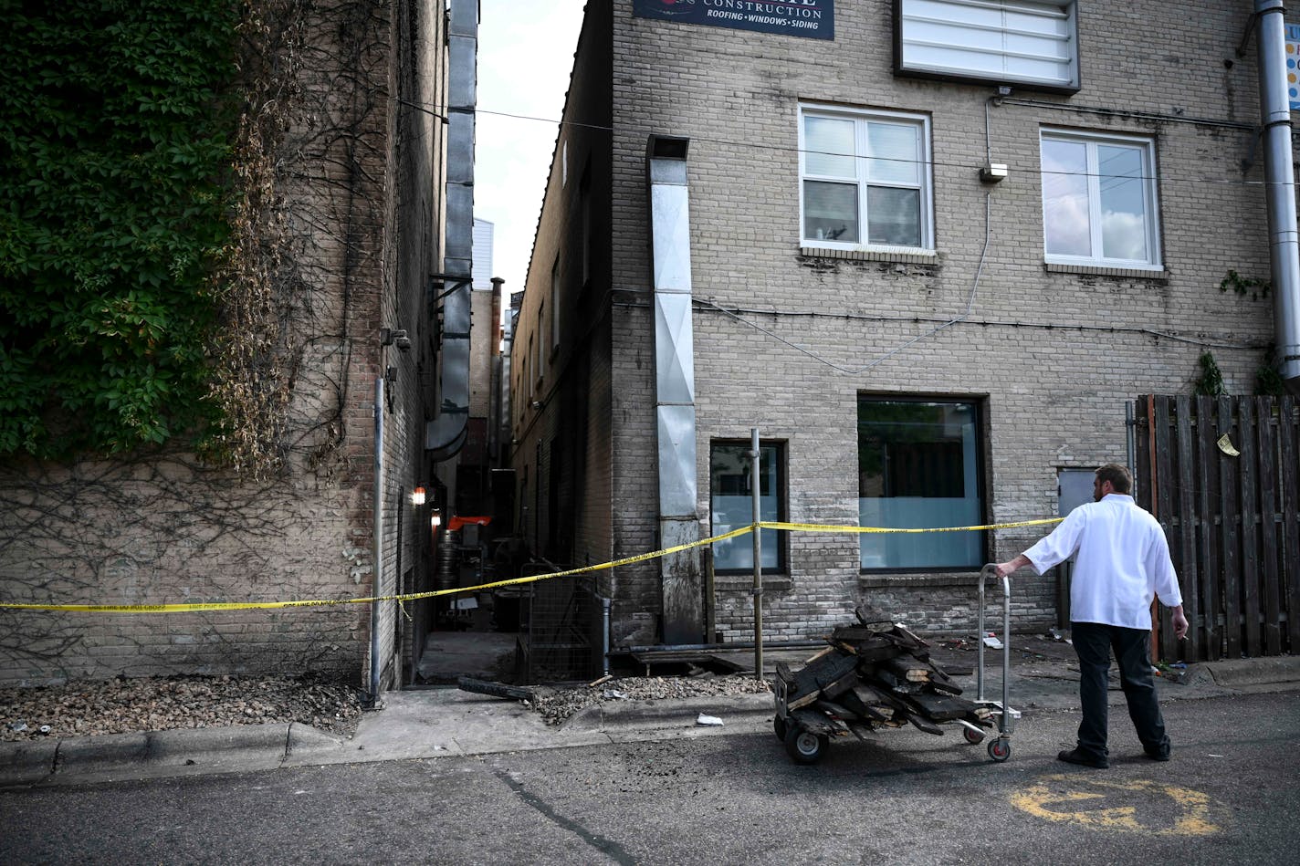 A Stella's Fish Cafe employee, who did not wish to be identified, carted away debris from an intentionally set fire behind the restaurant Friday night in Uptown.