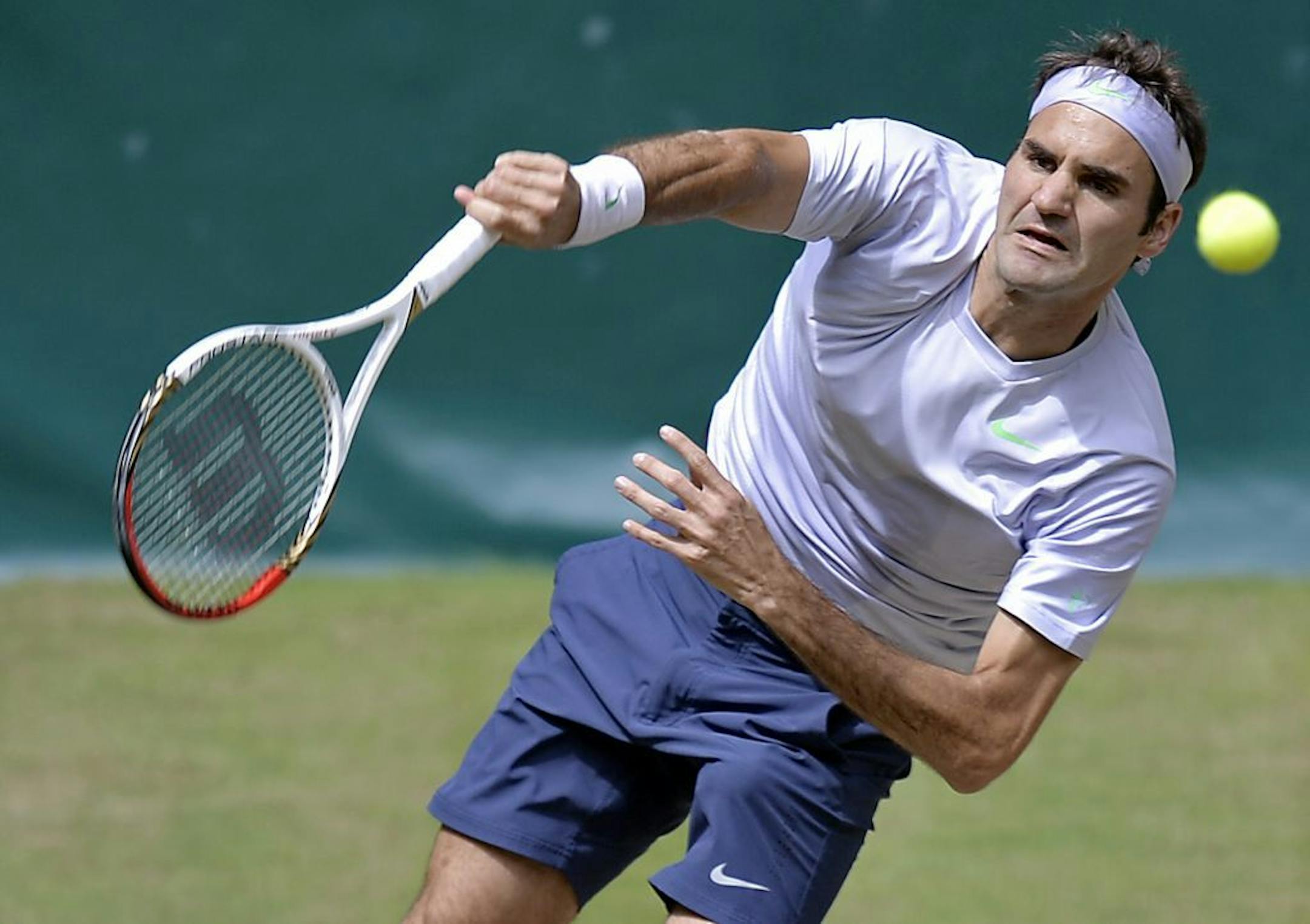 Switzerland's Roger Federer serves the ball to Mikhail Youzhny of Russia during the final of the ATP Gerry Weber Open tennis tournament in Halle , Westphalia, Germany, Sunday, June 16, 2013.