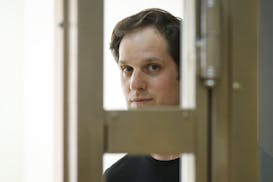 Wall Street Journal reporter Evan Gershkovich stands in a glass cage in a courtroom at the Moscow City Court in Moscow on June 22, 2023.