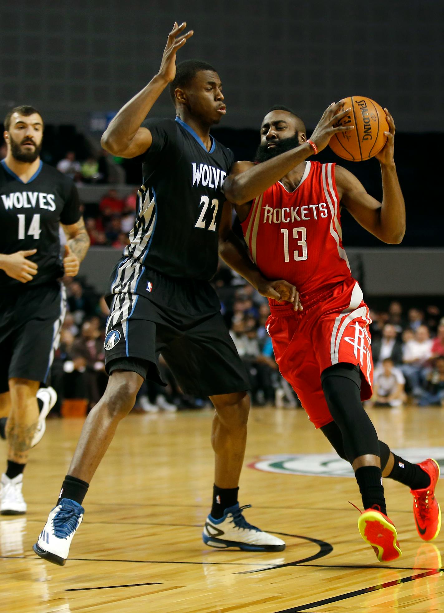 Houston Rockets' James Harden (13), right, dives to the basket as Minnesota Timberwolves' Andrew Wiggins (22) defends during the first half of an NBA basketball game in Mexico City, Wednesday, Nov. 12, 2014. (AP Photo/Eduardo Verdugo)