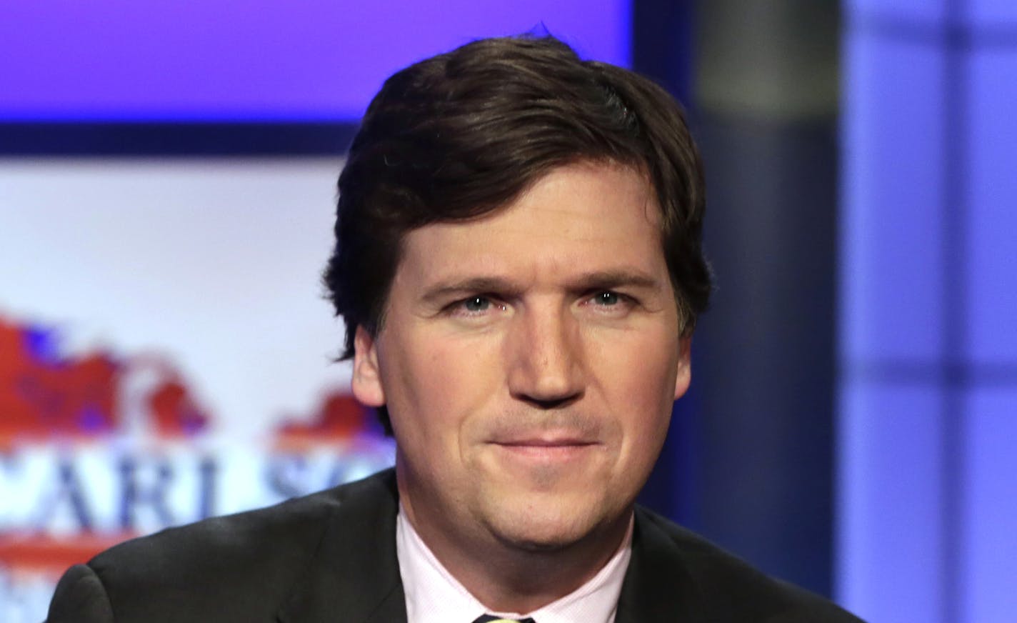 FILE - In this March 2, 2017, file photo, Tucker Carlson, host of "Tucker Carlson Tonight," poses for photos in a Fox News Channel studio in New York. Washington police are investigating a protest outside the home of Carlson as a possible hate crime. According to a police report, a group of demonstrators gathered outside Carlson's Northwest Washington home Wednesday night, Nov. 7, 2018. A video posted on social media but later removed shows people standing outside a darkened home chanting "Tucke