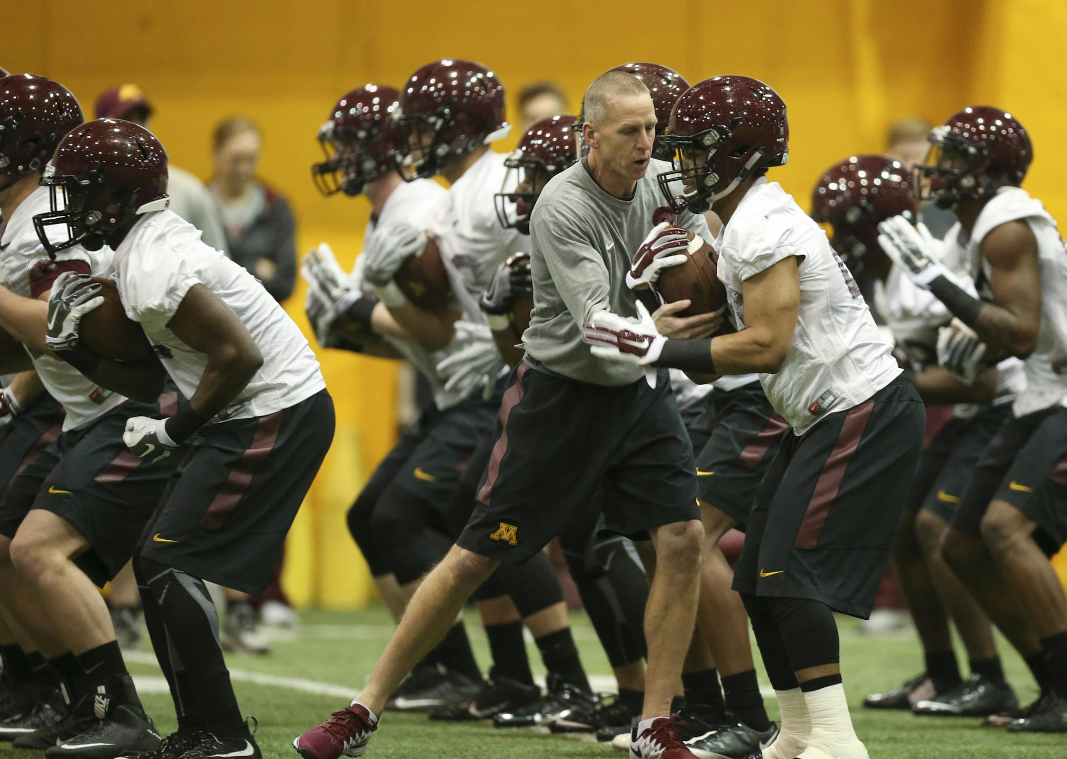 Offensive coordinator Jay Johnson gave running back Rodney Smith pointers on a ball-security drill. “The last rule on everything on offense is to squeeze the ball,” coach Tracy Claeys said.