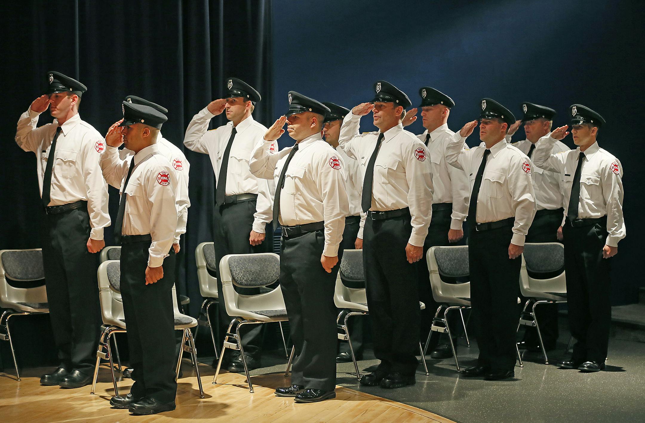 Eleven St. Paul Firefighter Graduates saluted the color guard during graduation at St. Paul College, Friday, September 19, 2014 in St. Paul, MN. The graduates included Mike Christopherson, whose father and grandfather were also St. Paul firefighters. ] (ELIZABETH FLORES/STAR TRIBUNE) ELIZABETH FLORES • eflores@startribune.com