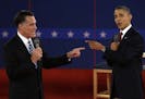 FILE - In this Oct. 16, 2012 file photo, Republican presidential nominee Mitt Romney, left, and President Barack Obama spar during the second presiden