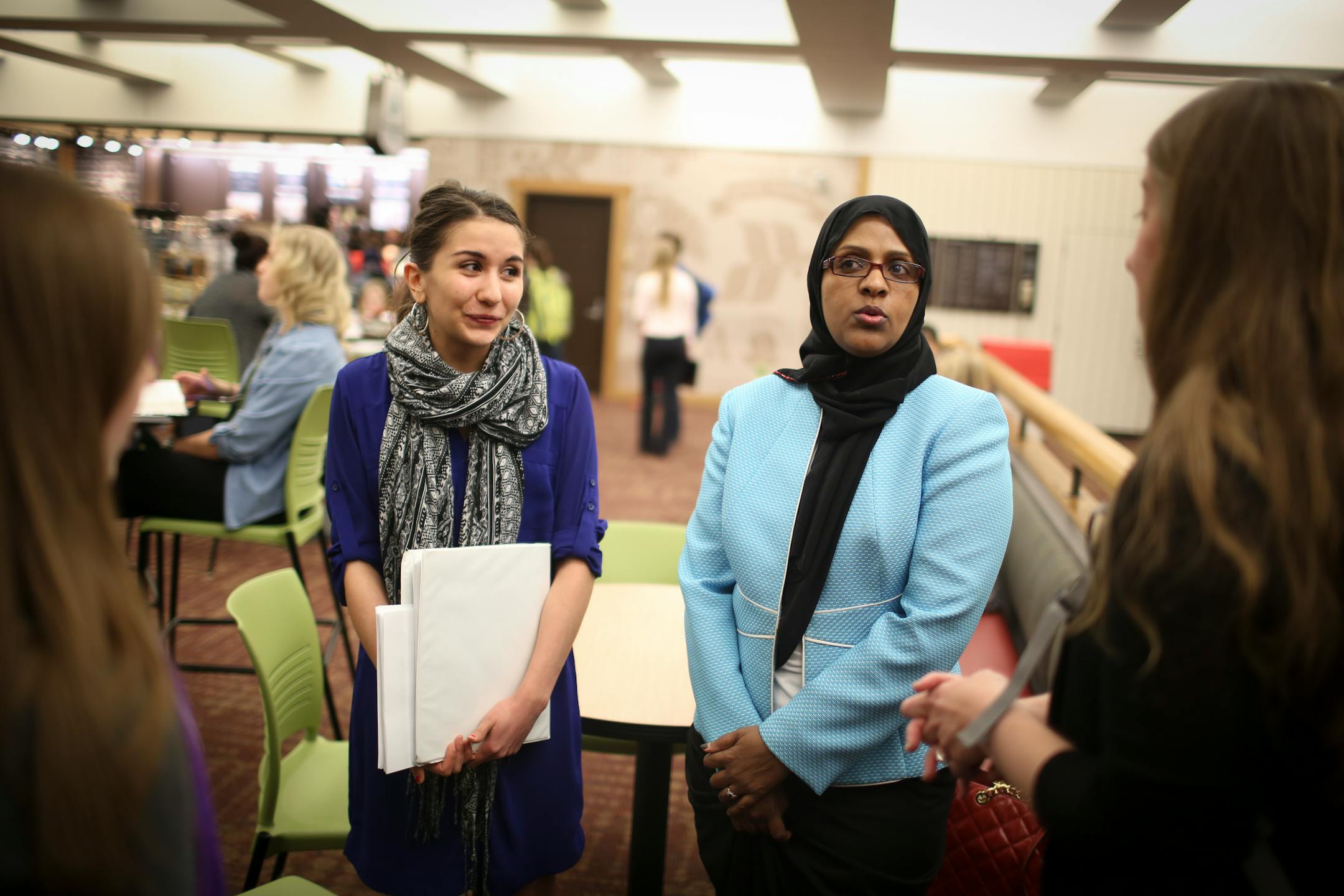 Fartun Weli, right, met with a group of women at a coffee shop before they walked her over to a lecture room where she gave a presentation on female genital cutting at a brown bag seminar for University of Minnesota medical students on Thursday, April 2, 2015 at the University of Minnesota in Minneapolis, Minn. At left is volunteer Hannah Aho. ] RENEE JONES SCHNEIDER ¥ reneejones@startribune.com