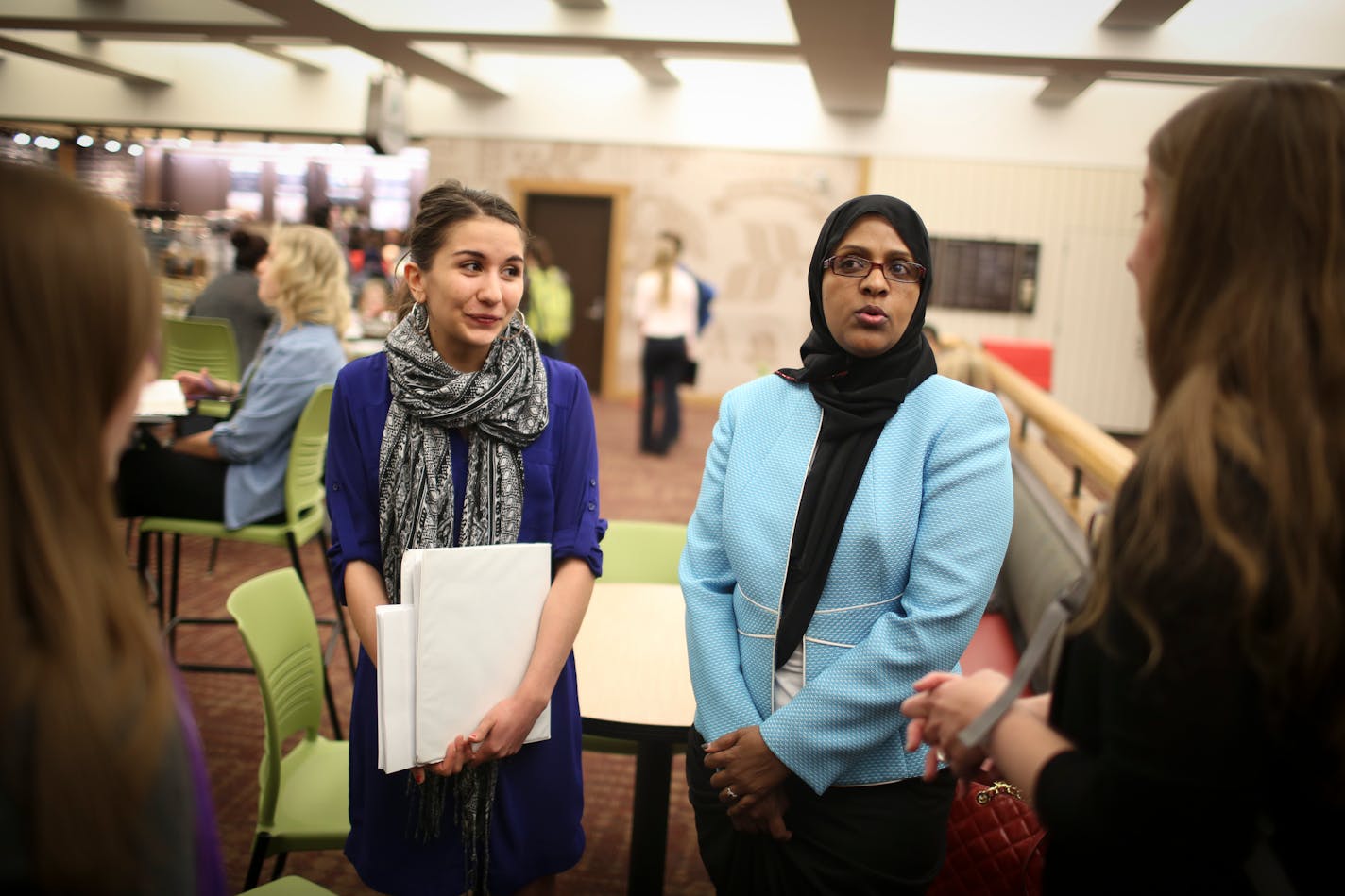 Fartun Weli, right, met with a group of women at a coffee shop before they walked her over to a lecture room where she gave a presentation on female genital cutting at a brown bag seminar for University of Minnesota medical students on Thursday, April 2, 2015 at the University of Minnesota in Minneapolis, Minn. At left is volunteer Hannah Aho. ] RENEE JONES SCHNEIDER ¥ reneejones@startribune.com