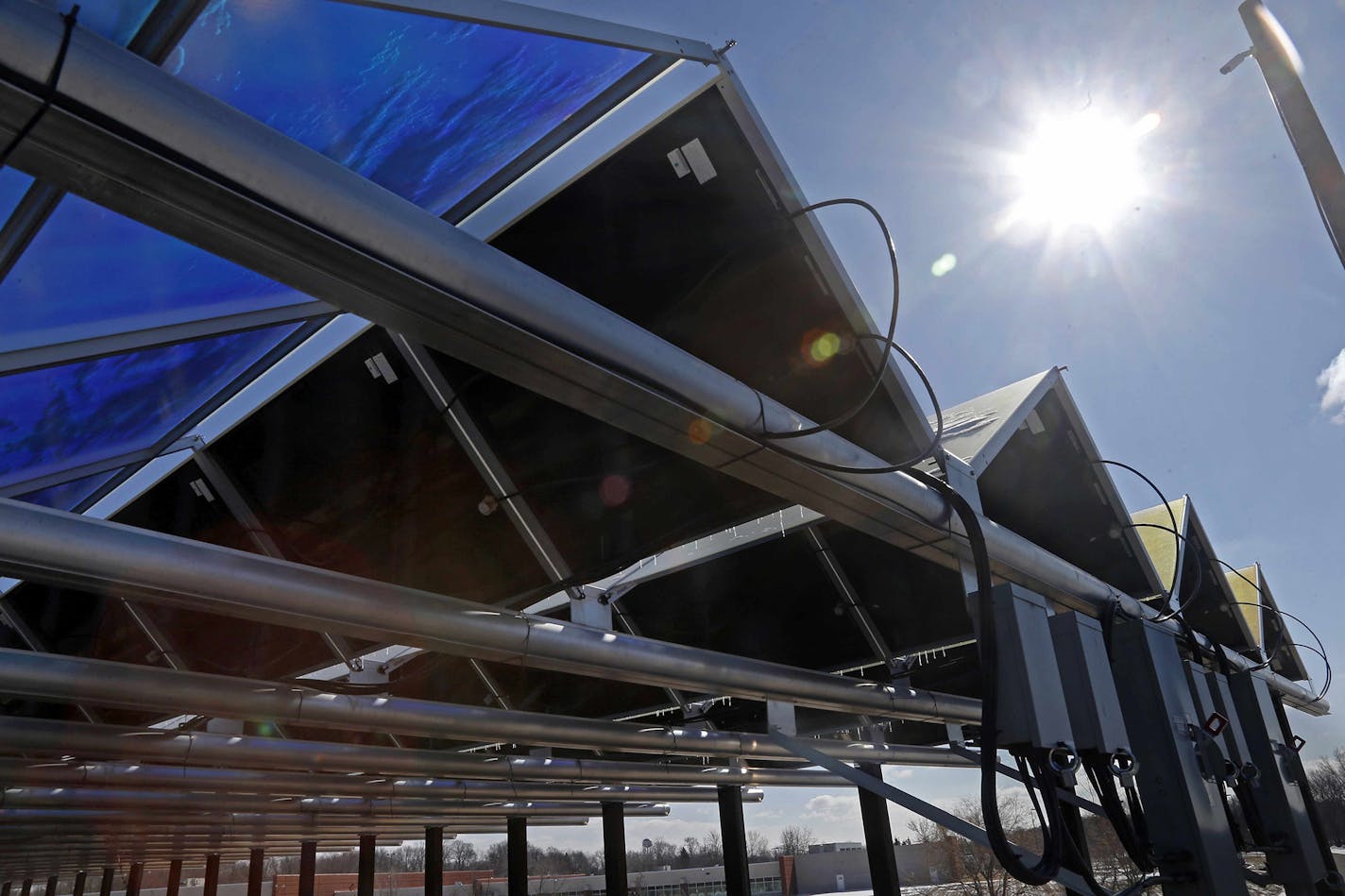 The sun shines down in 2015 on solar panels that are part of the Wright-Hennepin Cooperative Electric Association's community gardens in Rockford, Minn. (AP Photo/Jim Mone)