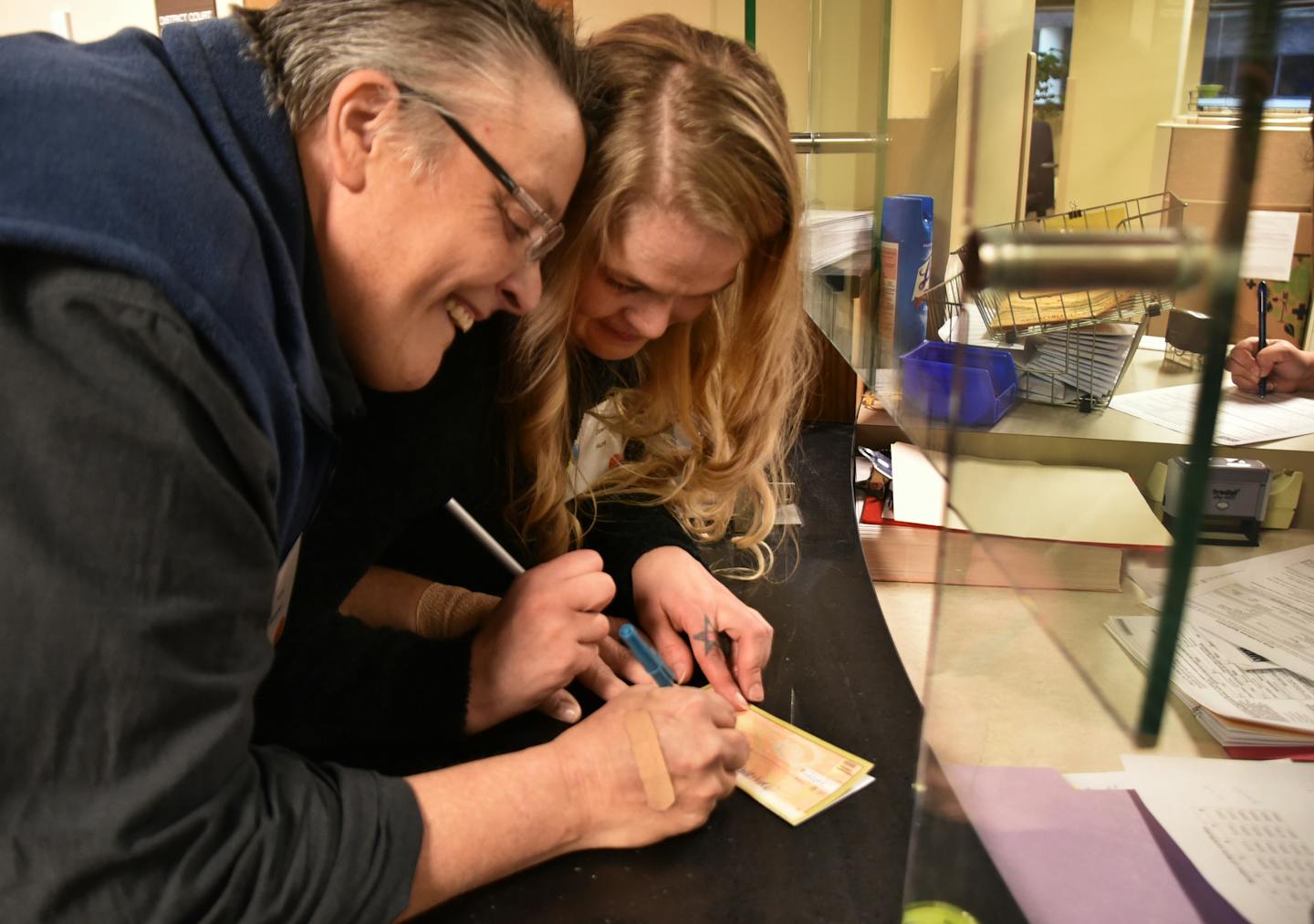 Amy Holubew and Dawn Hunt sign their names to legal papers during the adoption filing at District Court. ] On National Adoption Day this Saturday, 41 Hennepin County children will have a chance for a new beginning, and 27 families will embark on a new chapter in their lives together.Adoption Day is a time for celebration at the Juvenile Justice Center, as parents and children come together in a finalization hearing before a district court judge. 509940 Adopt_112314 20037105A (DAVID BREWSTER/STAR