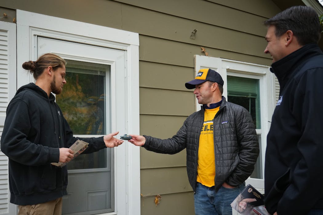 Republican Tom Weiler, center, running for Congress in Minnesota’s Third District, handed an Anoka resident a stress ball in the shape of a submarine with his campaign logo on it.