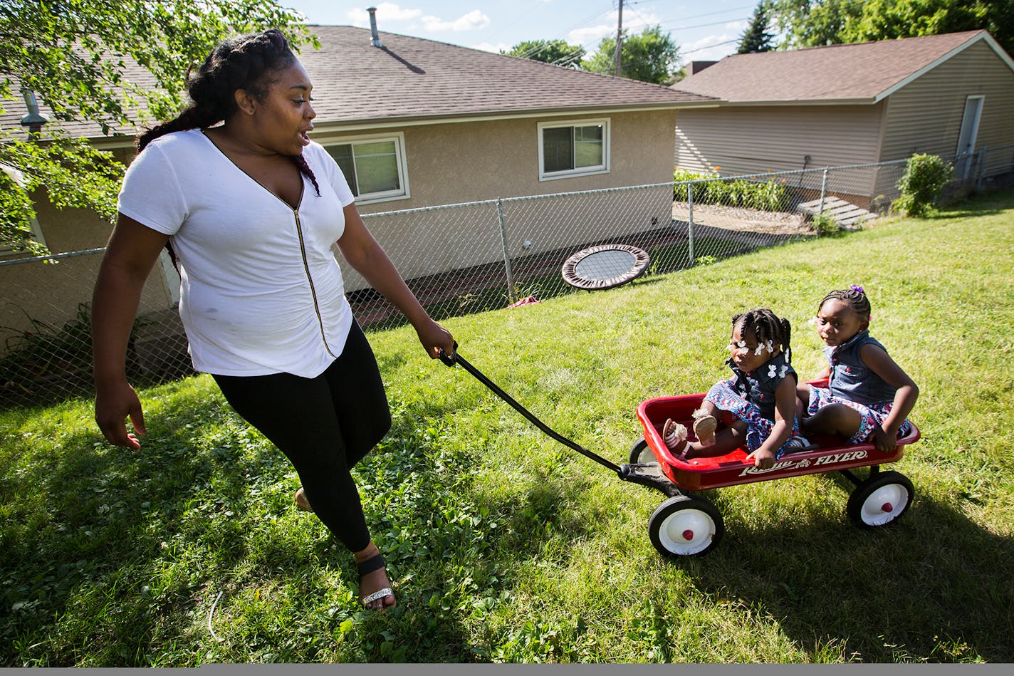 Autumn Mason pulls her daughters Reality, 2, and Reign, 4, in her mother's backyard. Her experience delivering Reality while incarcerated in Shakopee has helped shape new policies over the last two years to address the rapidly growing number of female offenders, some of whom are pregnant when they enter prison.