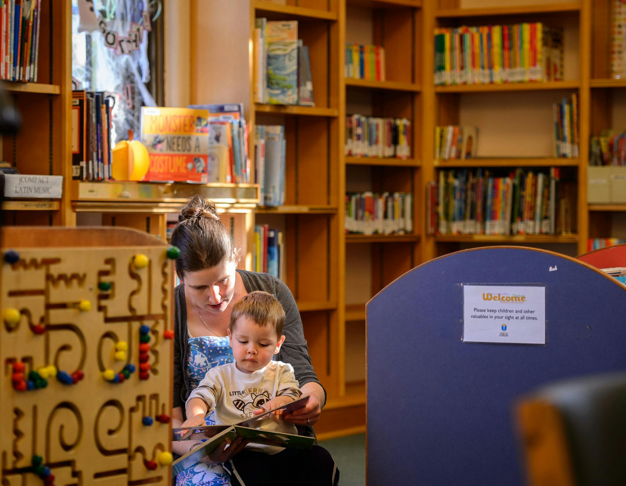 Christne Wainio read to her son Gilbert, 2, in the Arlington Hills Library. The St. Paul Public Library System is seeking a new owner for the Arlington Hills Library, one of three Carnegie libraries in the city and built in 1916 and listed on the National Register of Historic Places, who will retain it as a neighborhood and cultural asset. The library itself is moving to modern quarters on the East SIde. Thursday, October 10, 2013 ] GLEN STUBBE * gstubbe@startribune.com