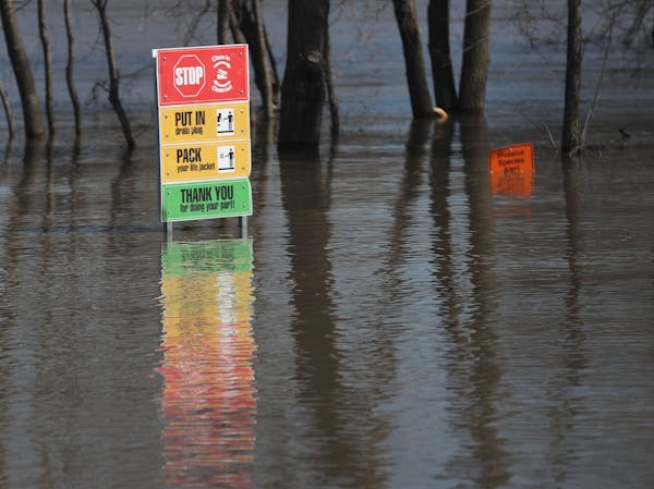 Signs are nearly underwater near Highway 19, where the Minnesota River is causing flooding and has closed down three of four highways heading into tow