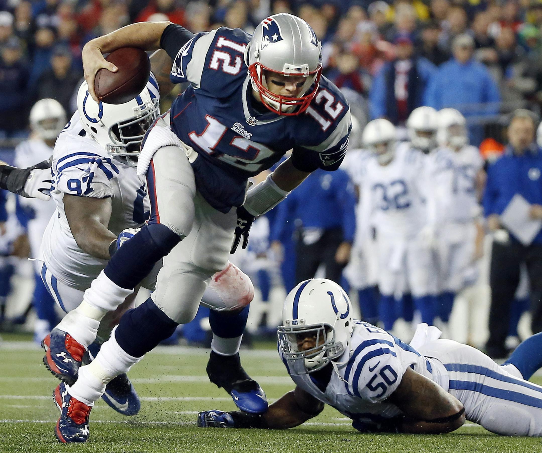 New England Patriots quarterback Tom Brady (12) gets away from Indianapolis Colts defensive end Arthur Jones (97) and linebacker Jerrell Freeman (50) during the first half of the NFL football AFC Championship game Sunday, Jan. 18, 2015, in Foxborough, Mass. (AP Photo/Elise Amendola)