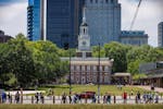 Visitors walk along the street by Independence Hall, where both the Declaration of Independence and the Constitution were debated and signed, in Phila