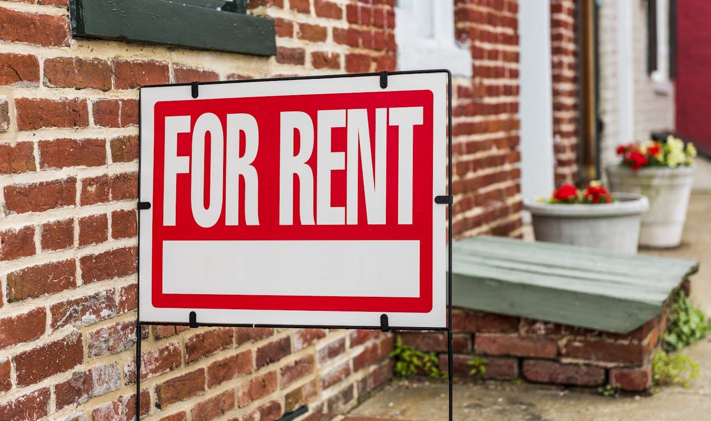 Red For Rent sign closeup against brick building