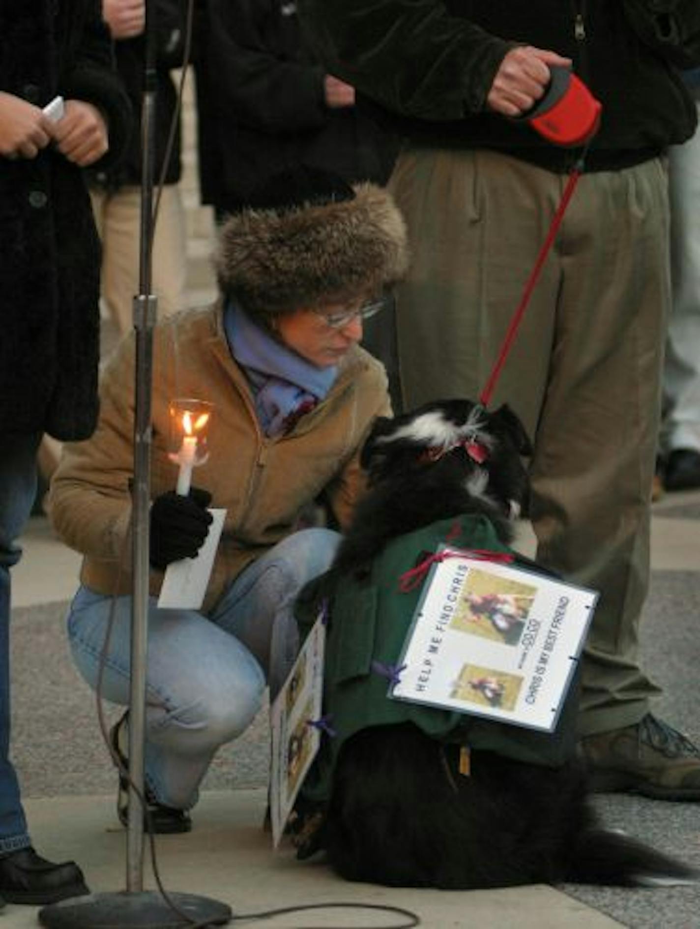 Minneapolis, MN Weds 11/06/2002 Jan Jenkins, the mother of missing U of M student Chris Jenkins attended to the family dog, Co Co, wearing a picture/sign ,-while her husband Steve and daughter Sara addressed the crowd at Northrop Plaza encouraging them to help locate Chris.