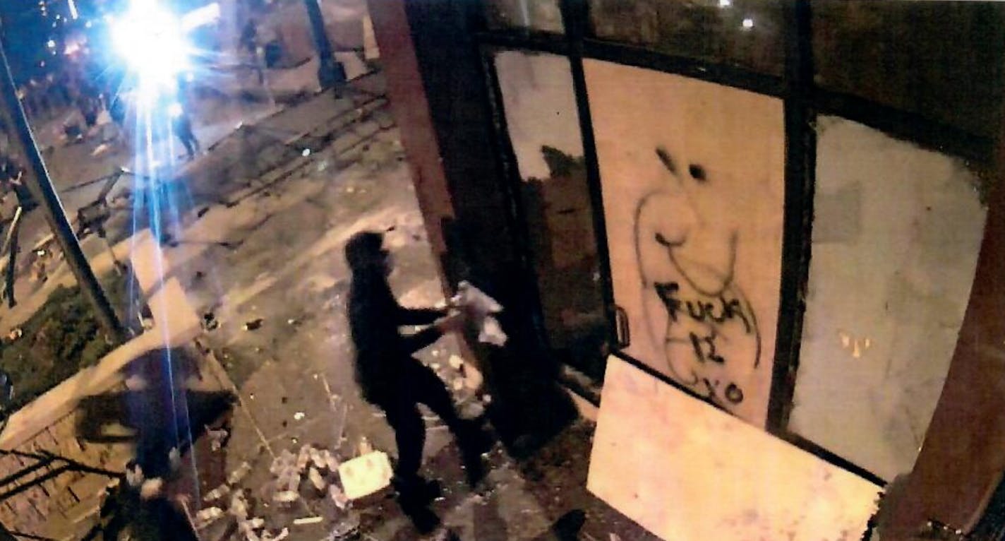 A federal criminal complaint states that police surveillance video captured this image of Bryce Michael Williams, armed with a Molotov cocktail, at the entrance of the Third Precinct before it was set afire.