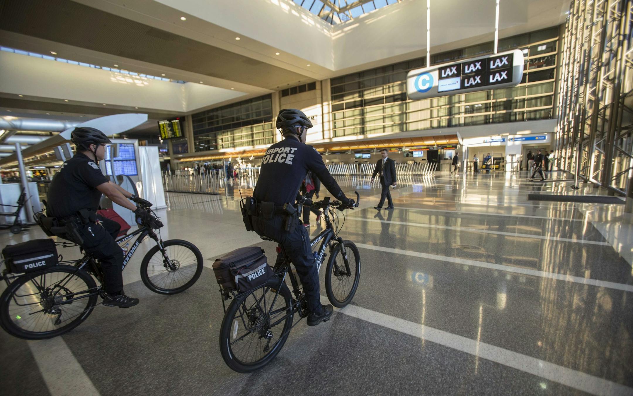 Police officers patrol the Tom Bradley International Terminal on Saturday, Nov. 2, 2013, in Los Angeles. A gunman armed with a semi-automatic rifle opened fire at Los Angeles International Airport on Friday, killing a Transportation Security Administration employee and wounding two other people in an attack that frightened passengers and disrupted flights nationwide. (AP Photo/Ringo H.W. Chiu)