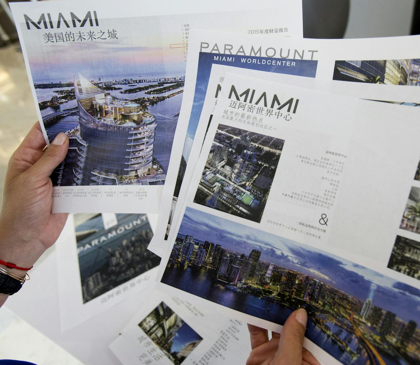 Peggy Fucci, CEO of OneWorld Properties, holds brochures written in Chinese for the Paramount Miami Worldcenter, in Fort Lauderdale, Fla. A nearly 40 percent plunge in the Shanghai stock market since mid-June has sent Chinese investors looking for safer investments. Some are focusing on U.S. real estate, including the condos Fucci&#xed;s real estate brokerage sells in Miami. She&#xed;s sold six condos to Chinese buyers in the past month, twice the number she&#xed;s typically sold. (AP Photo/Wilf