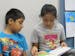 Photo by Erin Adler Third-grader Dayana Estrada Martinez read to her brother Esau Estrada Martinez, who is in first grade. Dayana takes a book home mo