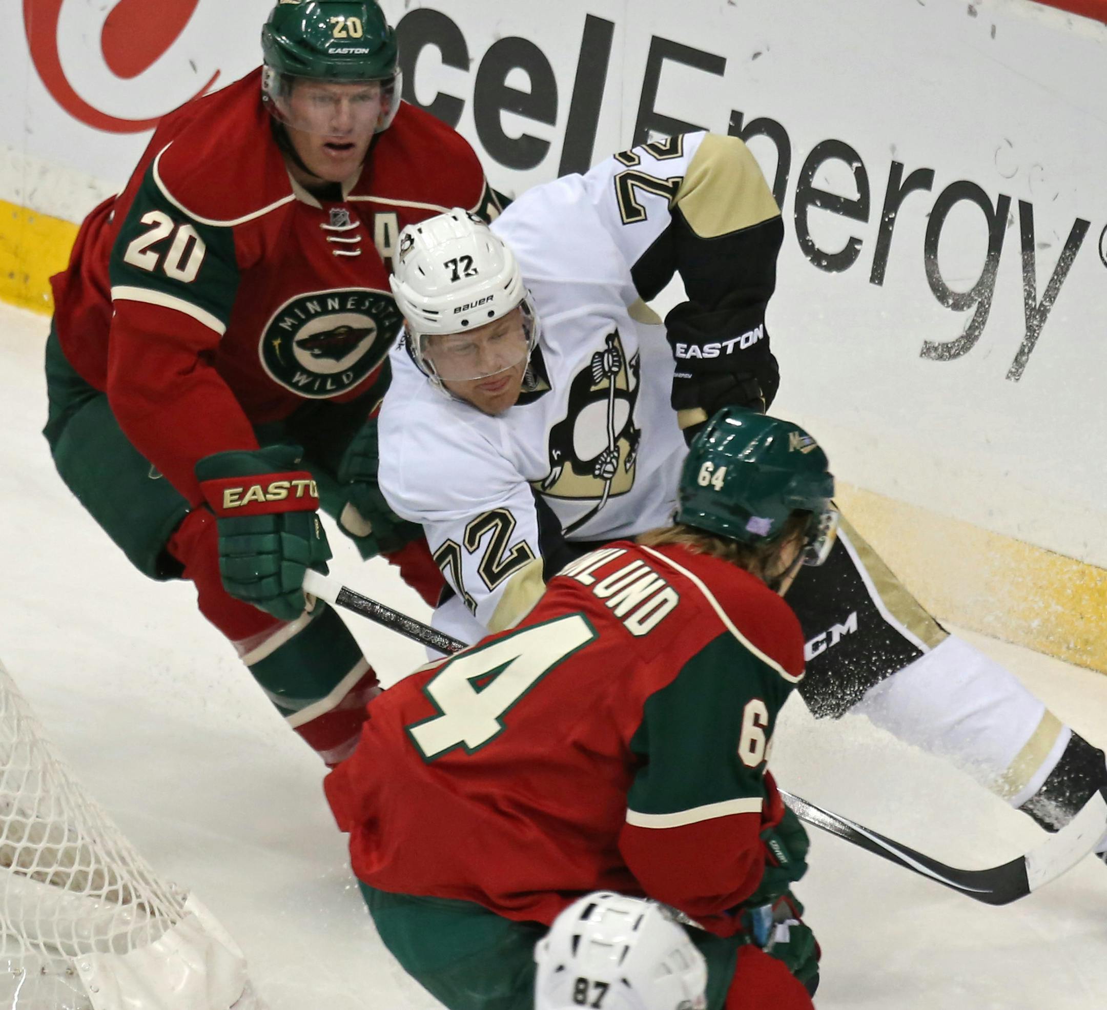 Pittsburgh Penguins' Patric Hornqvist, center, of Sweden, tries to get the puck past the Minnesota Wild defense of Ryan Suter and Mikael Granlund, of Finland, during the first period of an NHL hockey game, Tuesday, Nov. 4, 2014, in St. Paul, Minn. (AP Photo/Bruce Bisping