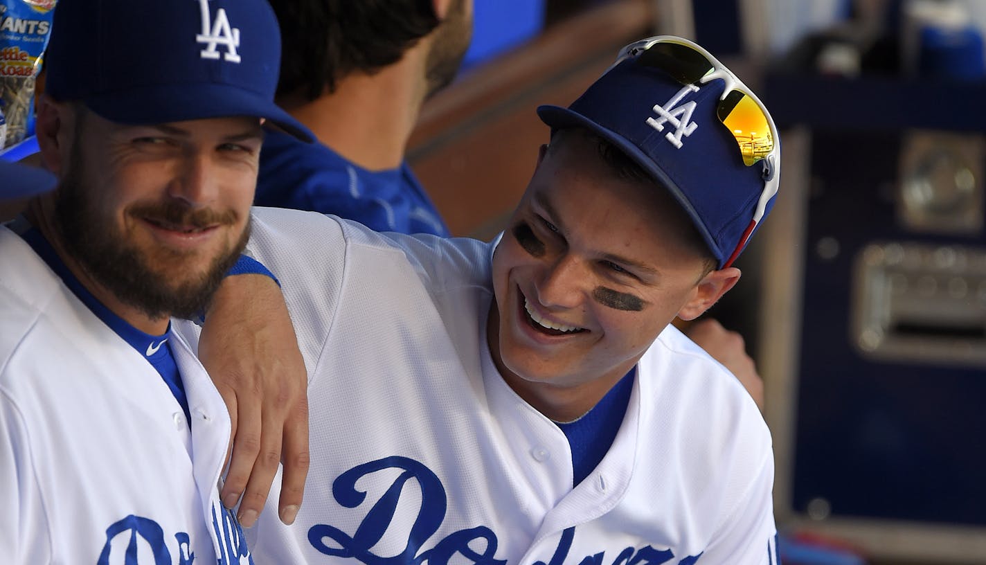 Los Angeles Dodgers' Joc Pederson, right, sits with Chris Heisey in the dugout prior to a baseball game against the St. Louis Cardinals, Sunday, June 7, 2015, in Los Angeles. (AP Photo/Mark J. Terrill) ORG XMIT: MIN2015061919091784