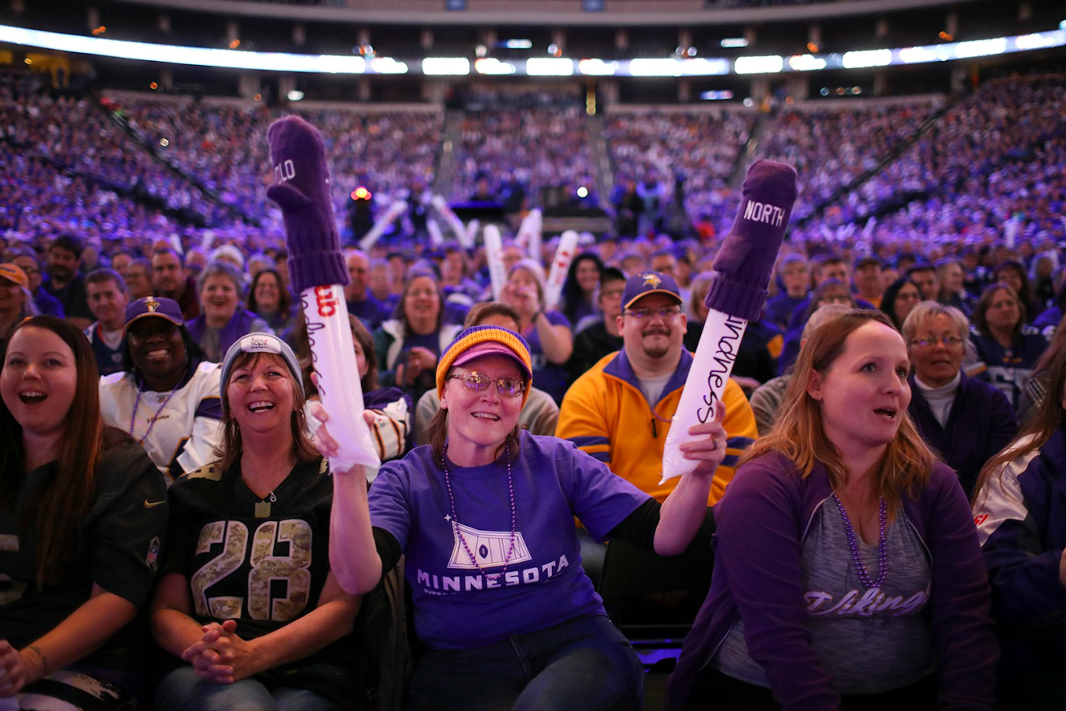 While seated in the front row of the main floor, Shelly Cheney, center, reacted to a speaker's remarks during the orientation for Super Bowl LII volunteers.
