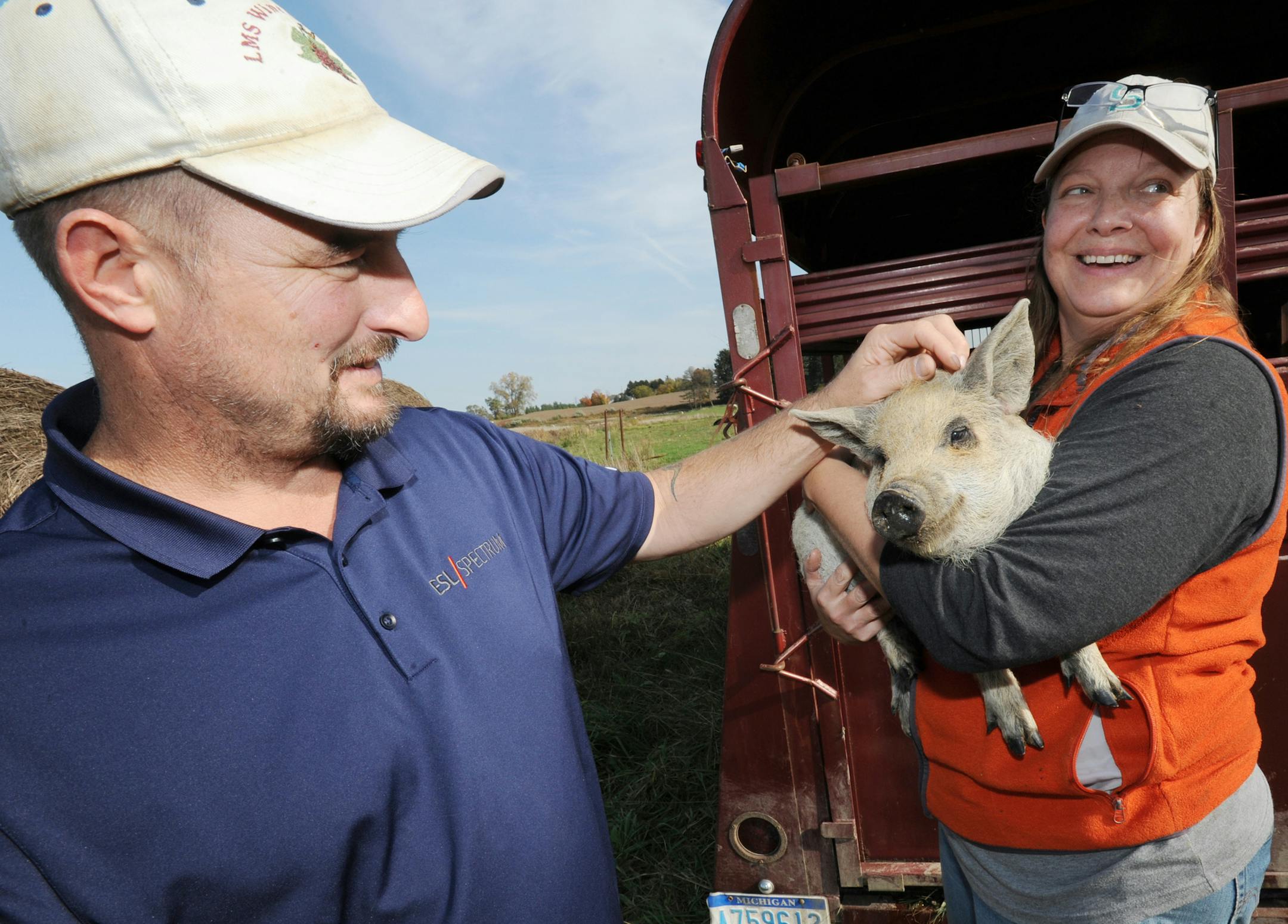 In this Tuesday, Nov. 1, 2016 photo, Mike and Michelle Deschaaf, owners of 1936 Meadowbrook Farm in Benton Harbor, Mich., show off a mangalitsa piglet. The farm has recently received certification as an Animal Welfare Approved pork producer in the state of Michigan.(Don Campbell/The Herald-Palladium via AP)