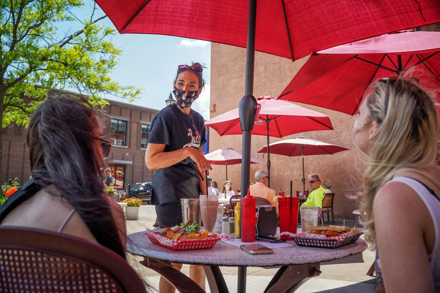 Angie Burger took orders and delivered drinks to customers in the restaurant's outdoor seating. Monday was the first day Minnesota restaurants were allowed to serve customers outdoors.