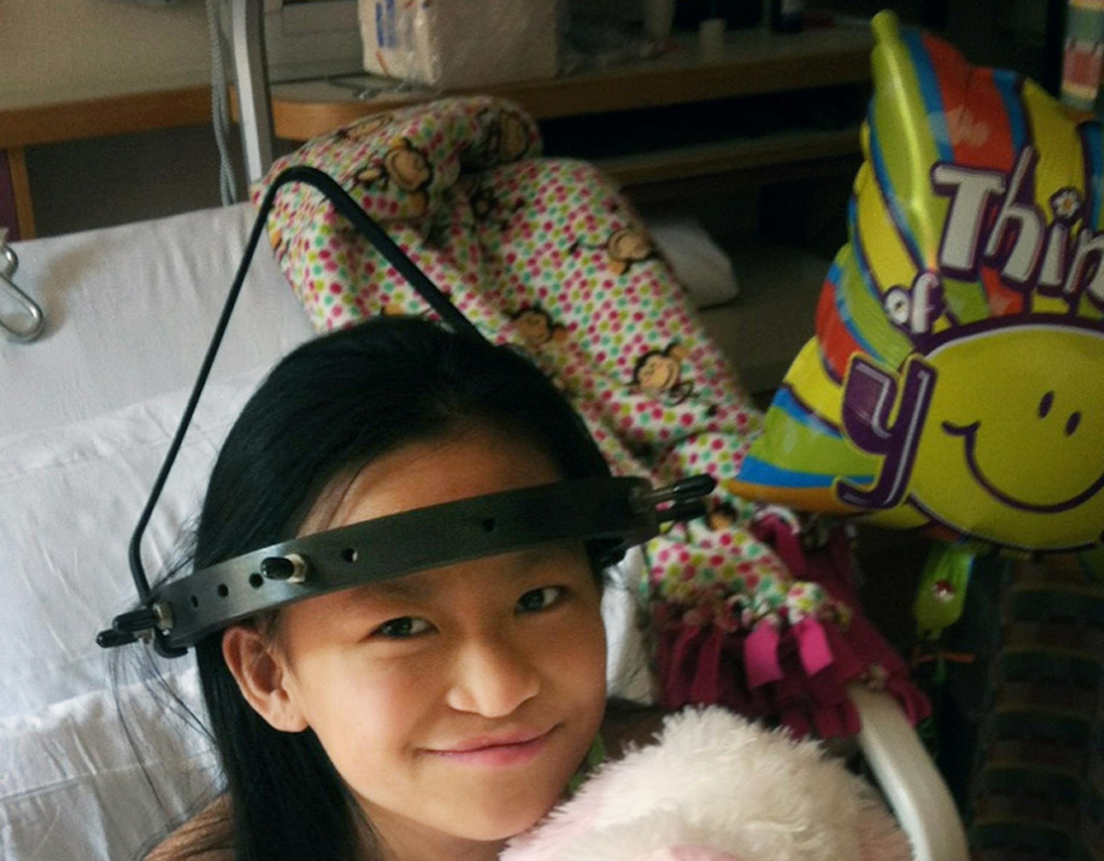 JunFen &#xa7;plays with her dog, Daisy, as she stretches her spine with a halo gravity traction device. &#xa7;
&#xa7; --- JunFen Freihammer spent 44 days at the Mayo Clinic this summer having rods put in her back to straighten out the curvature from her scoliosis birth defect. Photo provided by family.]richard tsong-taatarii/rtsong-taataarii@startribune.com