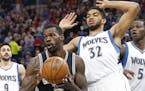 San Antonio Spurs' Dewayne Dedmon, left, pulls away from Minnesota Timberwolves defender Karl-Anthony Towns during the first half of an NBA basketball