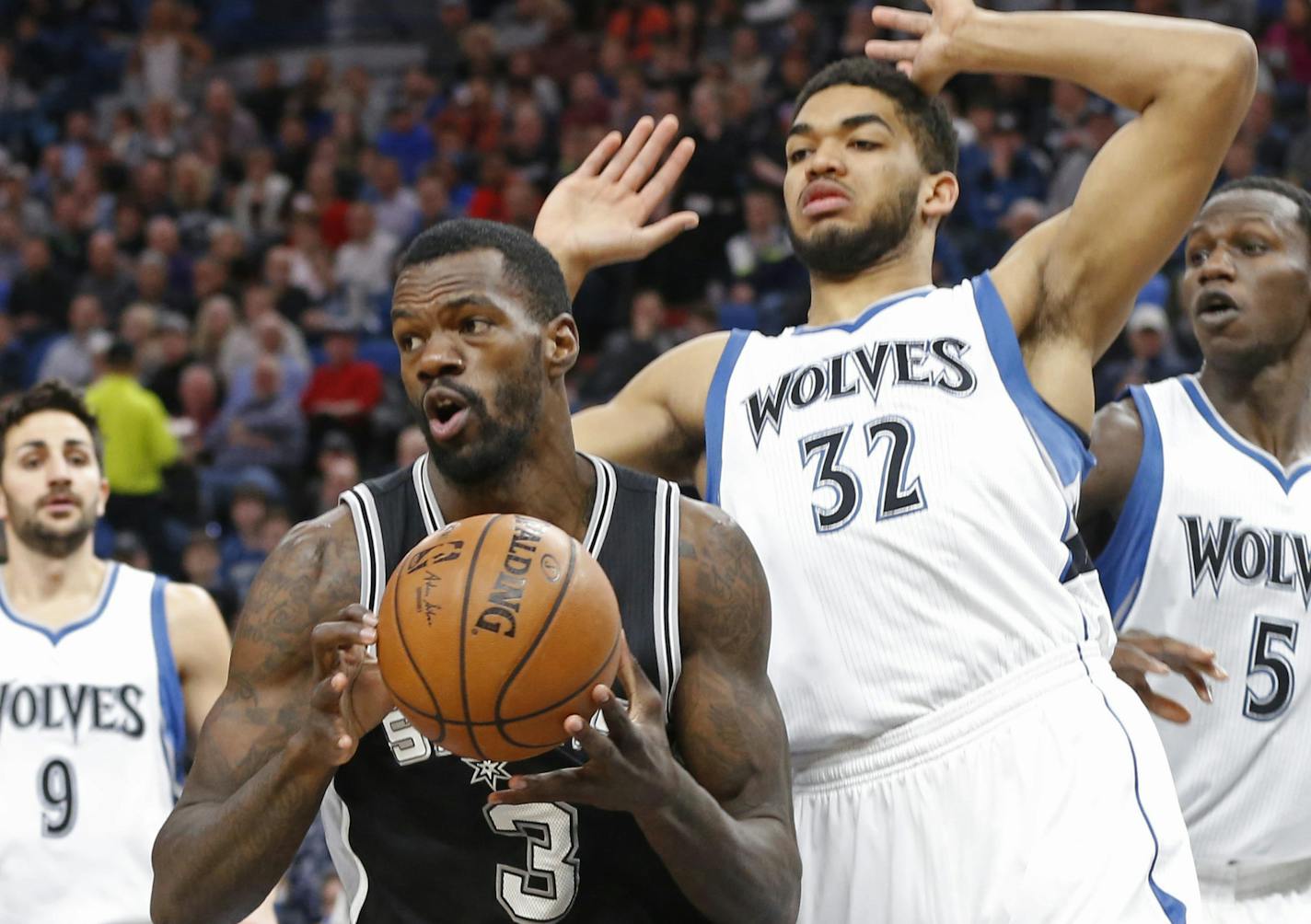 San Antonio Spurs' Dewayne Dedmon, left, pulls away from Minnesota Timberwolves defender Karl-Anthony Towns during the first half of an NBA basketball game Tuesday, March 21, 2017, in Minneapolis. (AP Photo/Jim Mone)