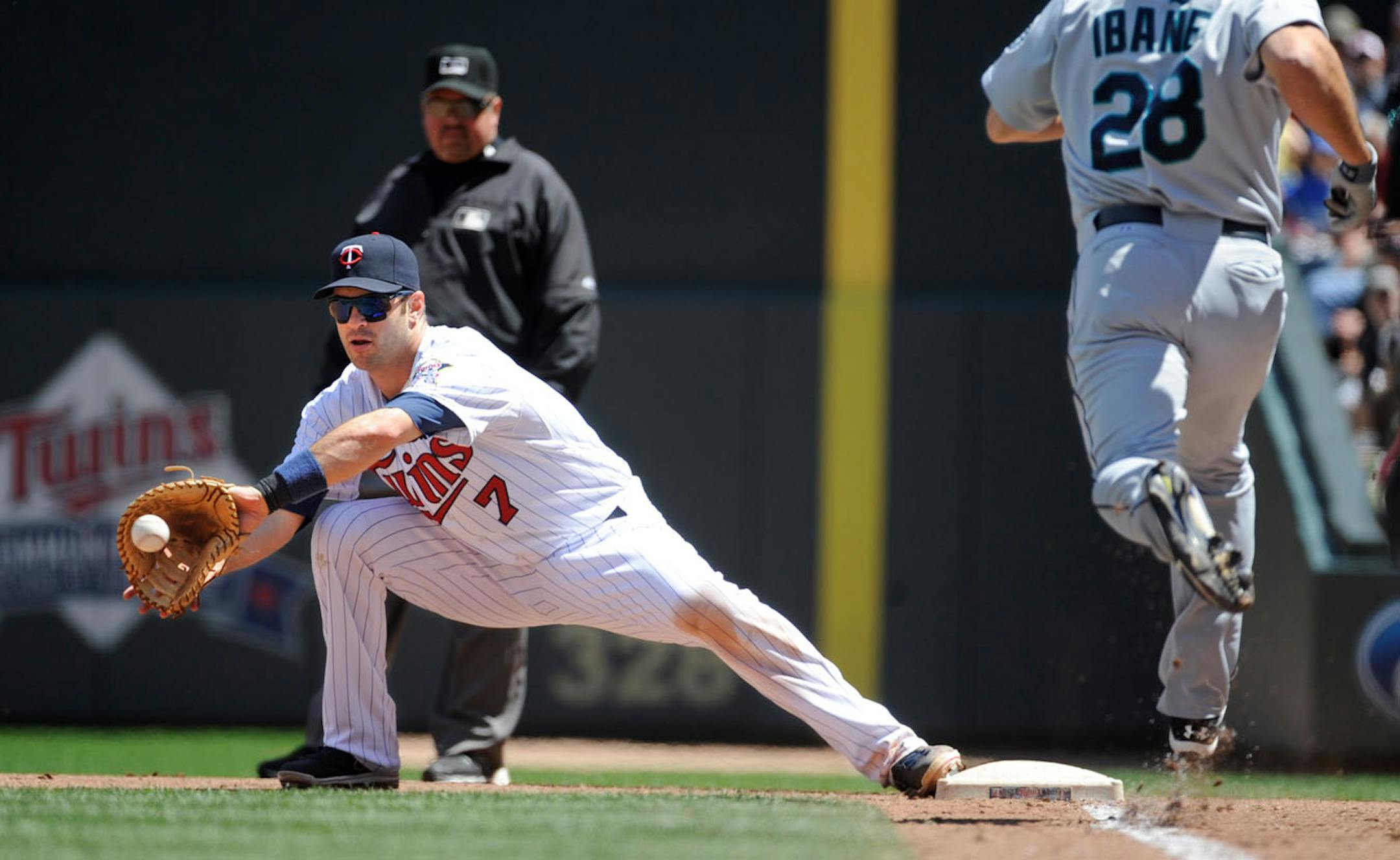 Minnesota Twins first baseman Joe Mauer, left, gets Seattle Mariners' Raul Ibanez out at first during the fourth inning of a baseball game on Sunday, June 2, 2013, in Minneapolis. (AP Photo/Craig Lassig)