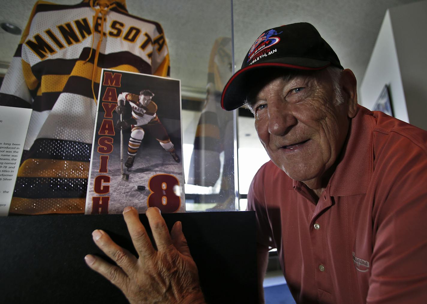 Profile of John Mayasich, now 80, one of the most prolific amateur hockey players in Minnesota during his playing days in the 1940's and 50's. He has retired to Eveleth, his hometown of hockey fame. John Mayasich with memorabilia from his Minnesota Gophers hockey team playing days on display at the Hockey Hall of Fame in Eveleth.