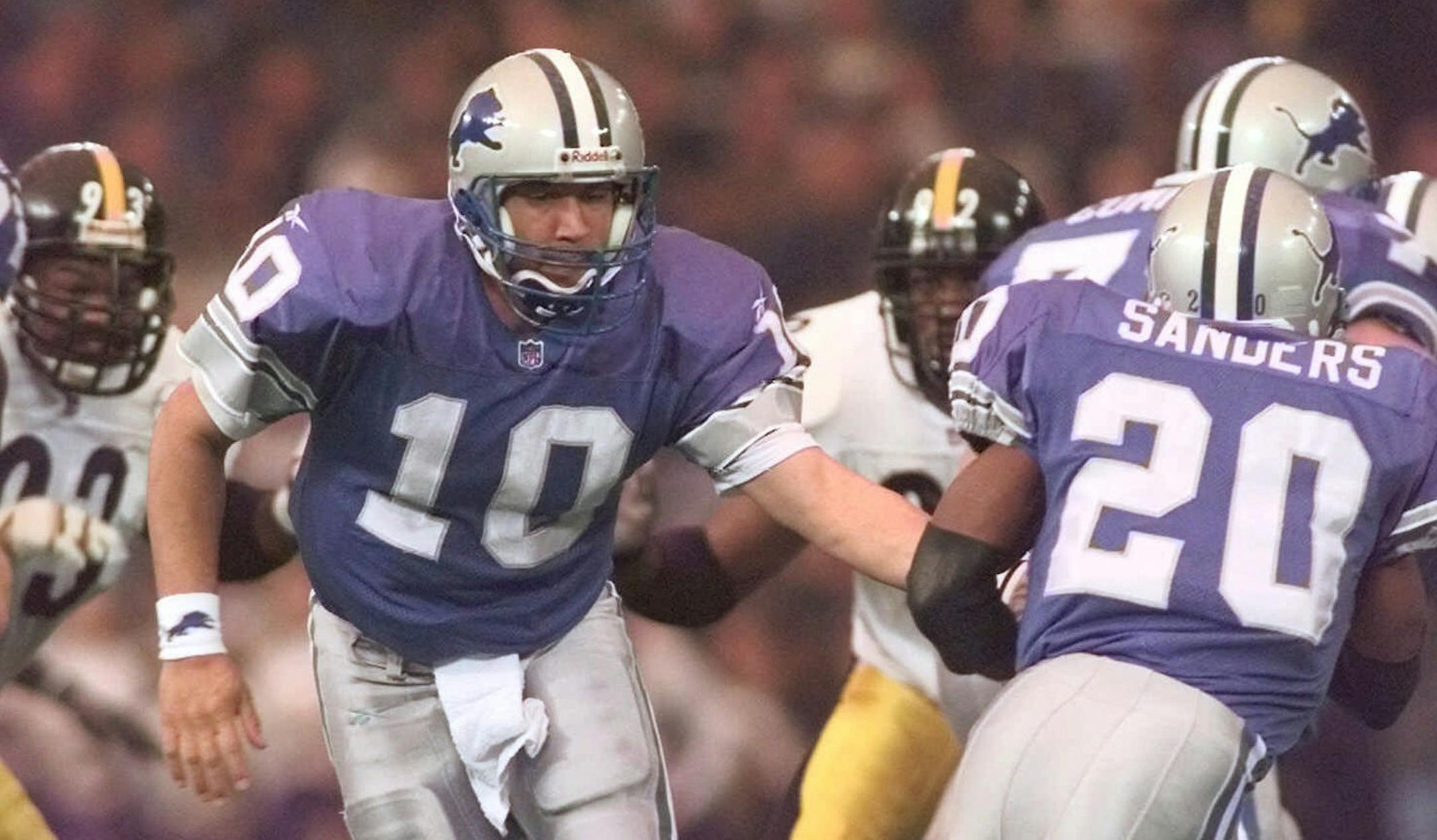 Detroit Lions quarterback Charlie Batch (10) hands the ball off to running back Barry Sanders during the second quarter against the Pittsburgh Steelers at the Silverdome in Pontiac, Mich., Thursday, Nov. 26, 1998. Batch completed 16 of 23 passes for 236 yards and one touchdown in the Lions' 19-16 overtime win over the Steelers. (AP Photo/Duane Burleson) ORG XMIT: DTC102