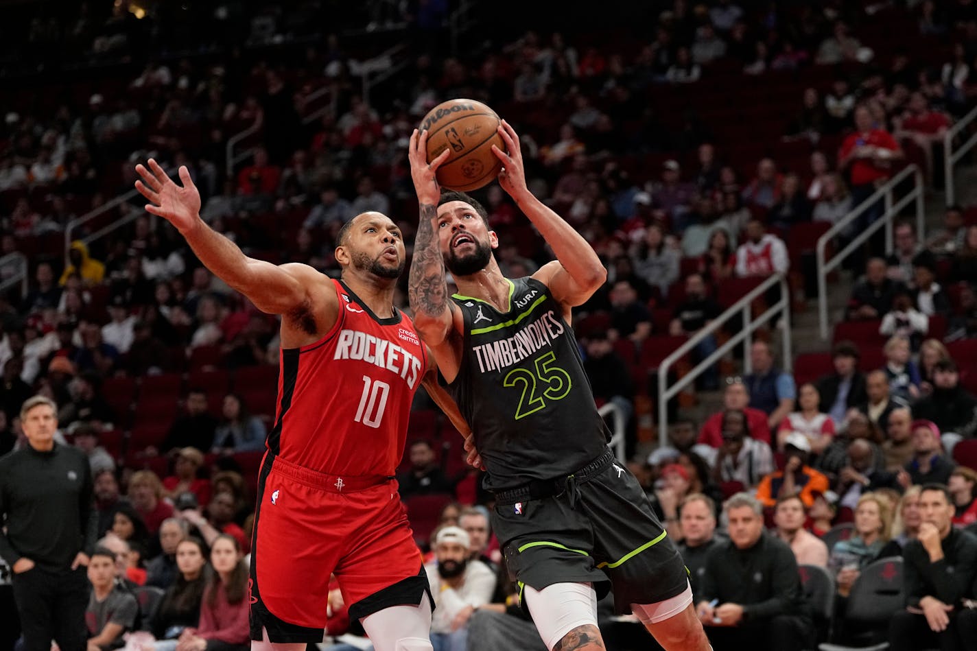 Austin Rivers of the Wolves goes up for a shot as the Rockets' Eric Gordon defends during the first half