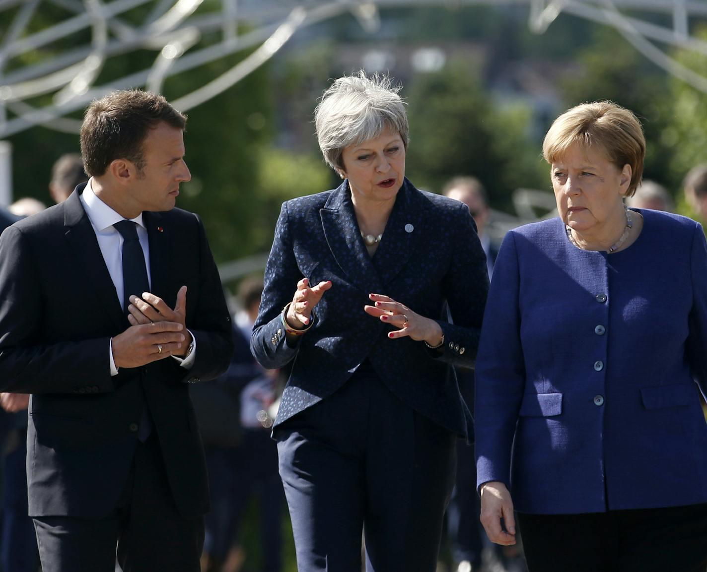 German Chancellor Angela Merkel, right, speaks with French President Emmanuel Macron, left, and British Prime Minister Theresa May after meeting at a hotel on the sidelines of the EU-Western Balkans summit in Sofia, Bulgaria, Thursday, May 17, 2018. (AP Photo/Darko Vojinovic) ORG XMIT: XDMV108