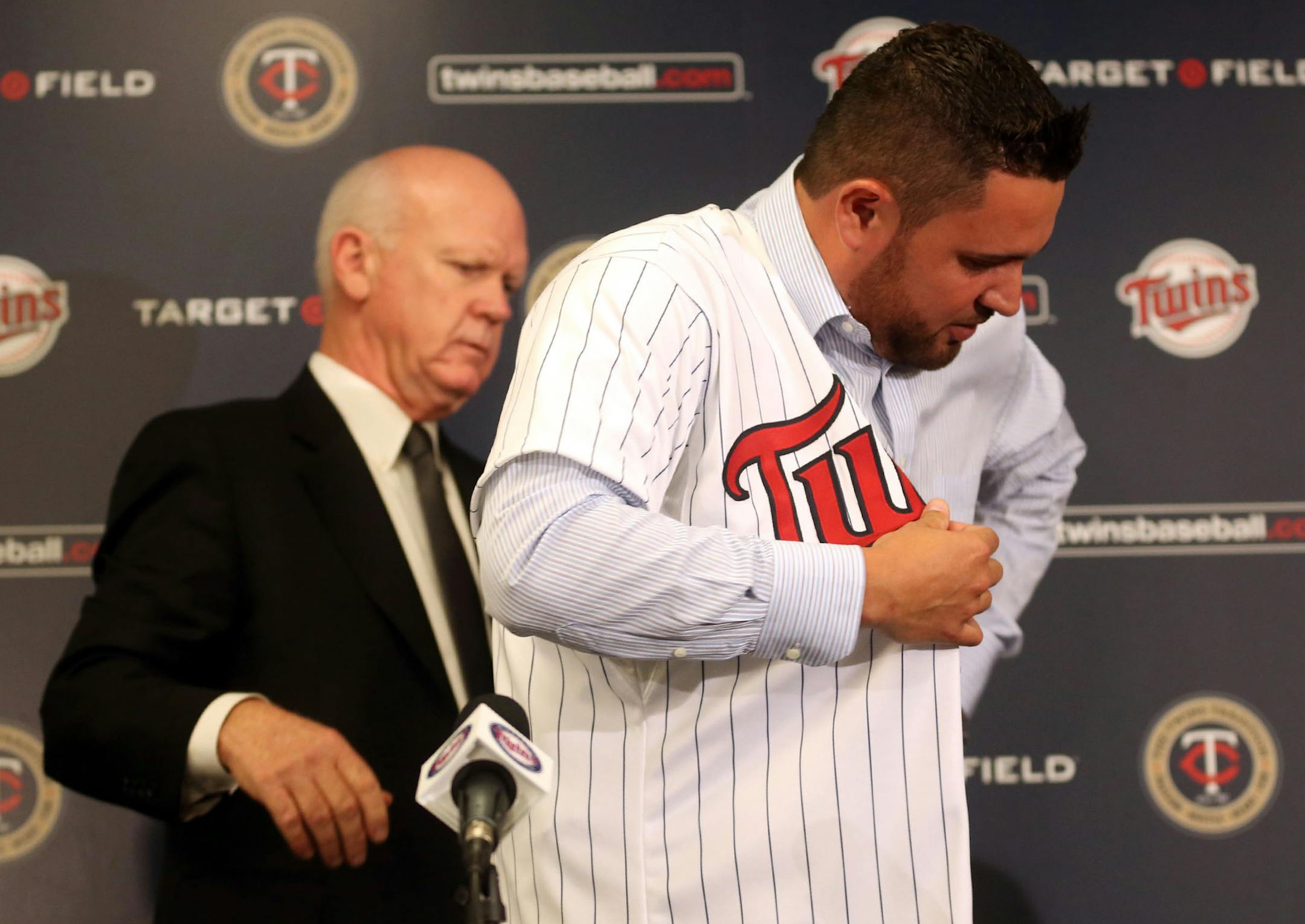 Twins general manager Terry Ryan helped free-agent signee Ricky Nolasco with his new jersey during a press conference at Target Field on December 3, 2013.