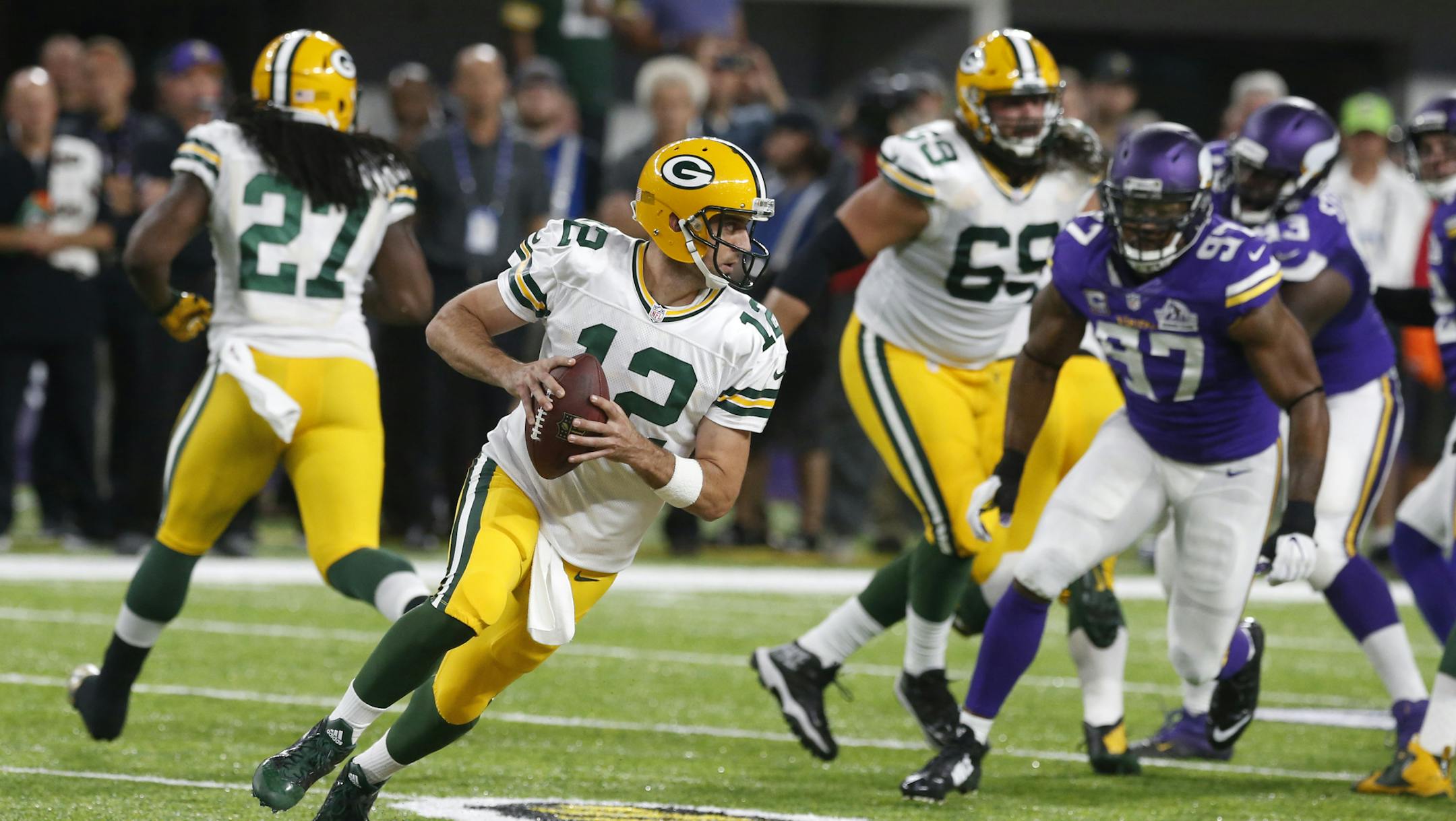 Green Bay Packers quarterback Aaron Rodgers (12) runs from Minnesota Vikings defensive end Everson Griffen (97) during the first half of an NFL football game Sunday, Sept. 18, 2016, in Minneapolis. (AP Photo/Jim Mone)