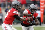 Ohio State quarterback J.T. Barrett, left, and running back Curtis Samuel play against Michigan in an NCAA college football game Saturday, Nov. 26, 20