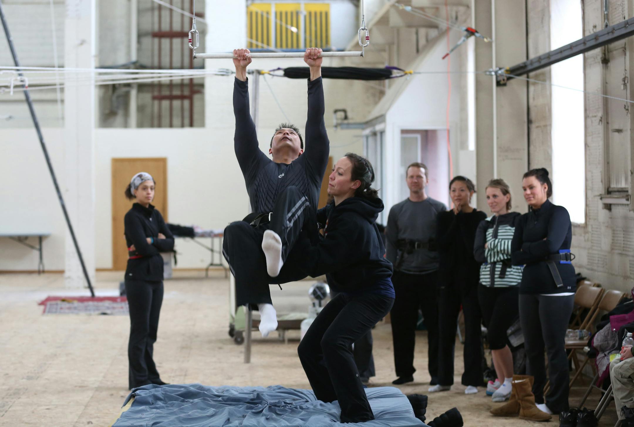 Katie Kimball instructor at the trapeze school helped Jae Wiese grab the bar during a small class Sunday March, 10, 2013 at a new trapeze school in the old Hamm's brewery in St. Paul, MN.] JERRY HOLT ‚Ä¢ jerry.holt@startribune.com ORG XMIT: MIN1303111150540200