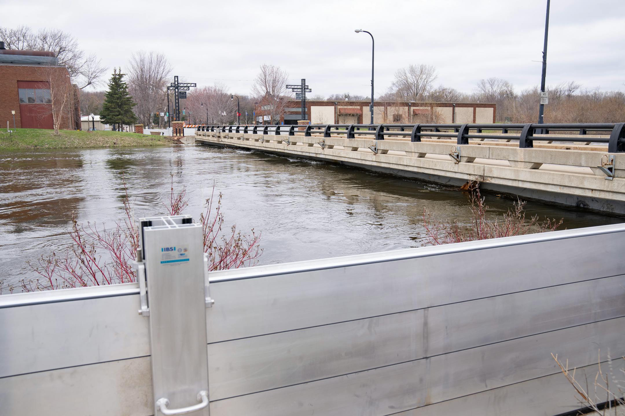 A flood wall stands on the bank of the Crow River as waters rise near Bridge Ave E. Wednesday, April 19, 2023, in Delano, Minn.