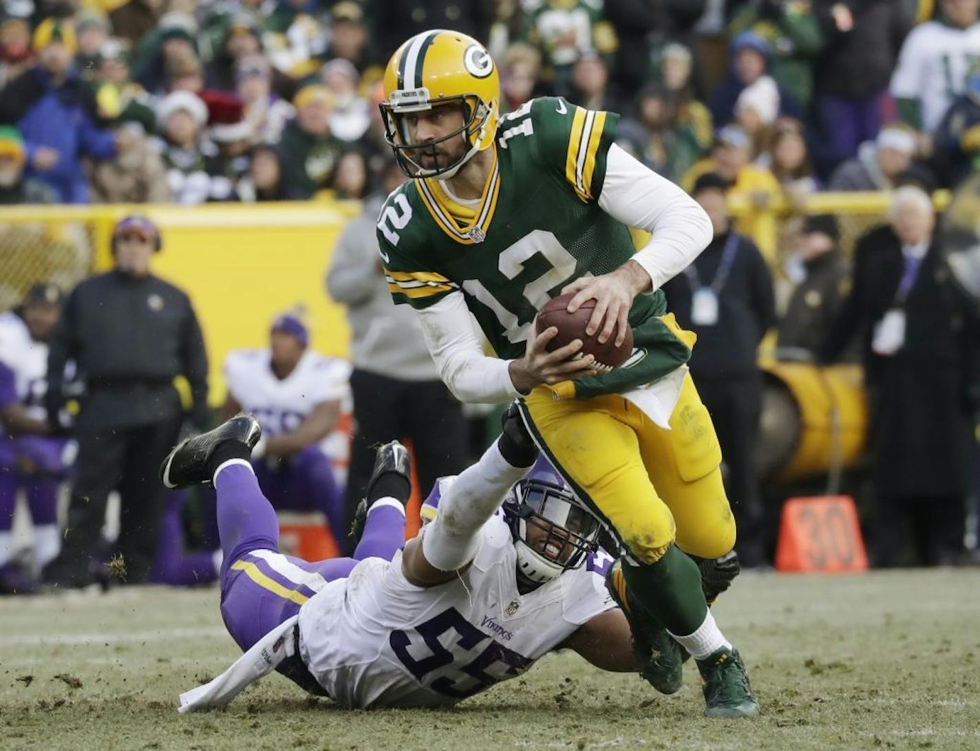 Green Bay Packers' Aaron Rodgers scrambles away from Minnesota Vikings' Anthony Barr during the second half of an NFL football game Saturday, Dec. 24, 2016, in Green Bay, Wis.