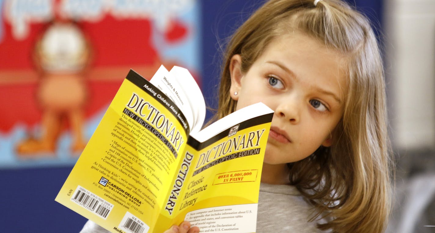 In this Nov. 29, 2016 photo, Erin Egan, a third grade student listens to retired attorney Ted Utchen who donated dictionaries to students at Park View Elementary School in Glen Ellyn, Ill. Utchen began his crusade against bad grammar roughly 14 years ago, and since then his quest really hasn't changed. "The Dictionary Man" brings little shtick to the vocabulary lesson he repeats every year for students in schools across DuPage County.(Daniel White/Daily Herald, via AP)